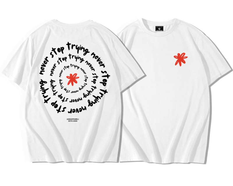 T-shirt oversize premium blanc SportiStyles présenté de face avec petit emblème rouge côté cœur et de dos avec symbole rouge central entouré du texte circulaire « never stop trying »